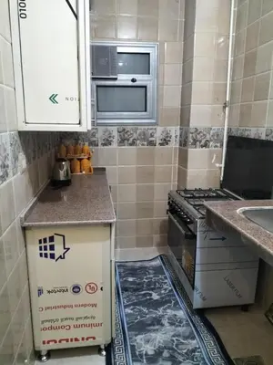 a small kitchen with a stove and a sink at El faraón egipcio apartment in Al Karnak