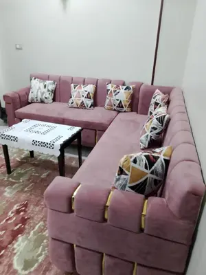a living room with a purple couch and a table at El faraón egipcio apartment in Al Karnak