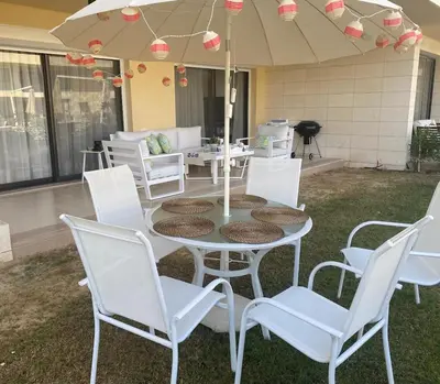 a patio with a table and chairs and an umbrella at Modern 3BR Poolside Apt at Cribs El Gouna in Hurghada