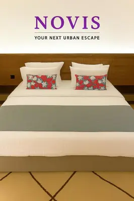 a bed with four pillows on it in a room at Novis Holiday Homes Sahl Hasheesh in Hurghada