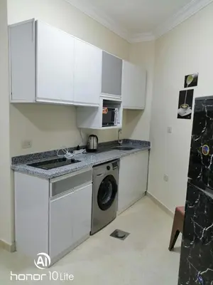 a kitchen with white cabinets and a washing machine at La quinta hights in Hurghada