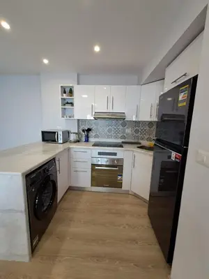 a kitchen with white cabinets and a dishwasher at Tawaya Sea View 2 bedrooms in Hurghada