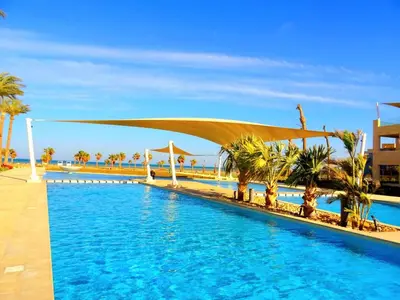 a swimming pool with palm trees and a canopy over it at El-Gouna in Hurghada