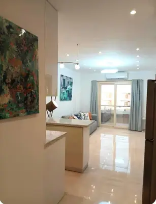 a kitchen and living room with a couch and a painting at Luxury Newly Built 2 DOUBLE bedroom and living room with Beach Access and Pool in Hurghada, Egypt in Hurghada