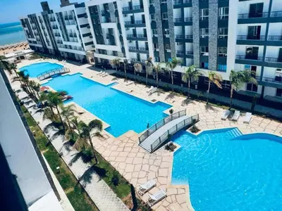 an overhead view of two swimming pools in front of a building at Fanadir Bay Elnoras213 Hurghada in Hurghada