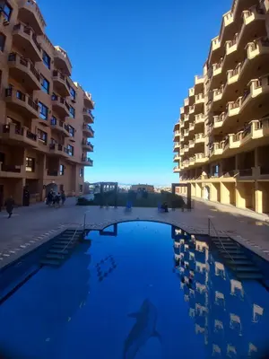 a swimming pool in front of some apartment buildings at Hurhgada concierge at Turtles beach resort in Hurghada