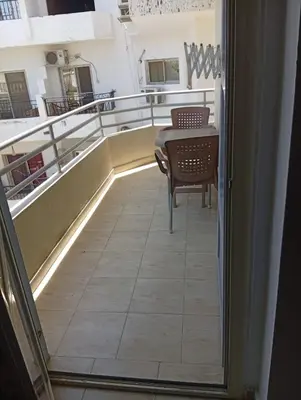 a balcony with a table and a chair at شقه للإيجار مكيفه in Hurghada