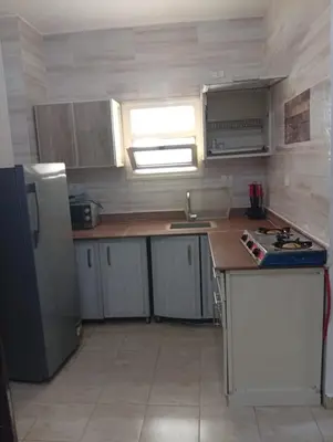 a small kitchen with a refrigerator and a sink at شقه للإيجار مكيفه in Hurghada