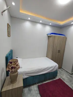 a bedroom with a bed and a table with a lamp at Oasis Resort Compound in Hurghada