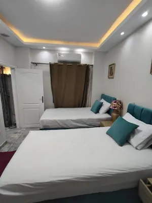 a bedroom with two beds and a door at Oasis marina الاحياء in Hurghada