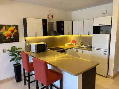 a kitchen with a counter with chairs and a microwave at Azzurra Sea&pool View 2Bedrooms in Hurghada