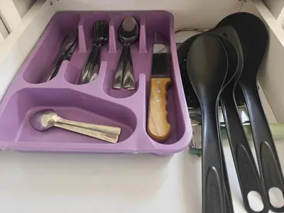 a purple tray filled with utensils on a shelf at Bayt Hassan S2 - Cosy 1 bedroom apartment in Hurghada