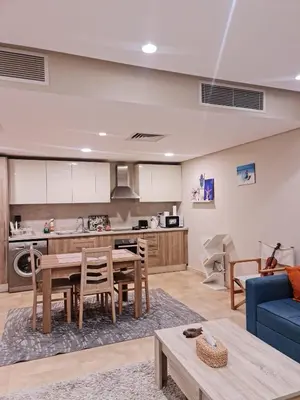 a living room with a table and a blue couch at 1 bedroom in mangroovy El gouna in Hurghada