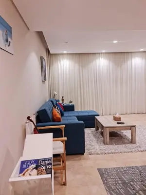 a living room with a blue couch and a table at 1 bedroom in mangroovy El gouna in Hurghada