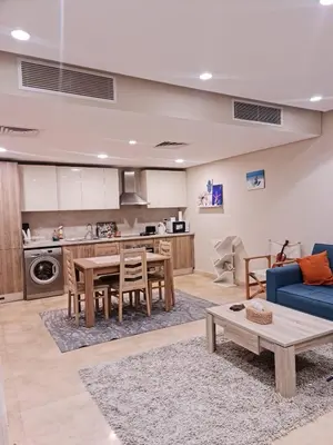 a living room with a table and a blue couch at 1 bedroom in mangroovy El gouna in Hurghada