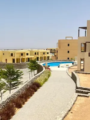 a pathway leading to a building with a swimming pool at Sea View Serenity - Stylish 2BR Retreat in Hurghada