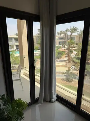 a glass door with a view of a yard at Cozy 2BR with pool access in Hurghada