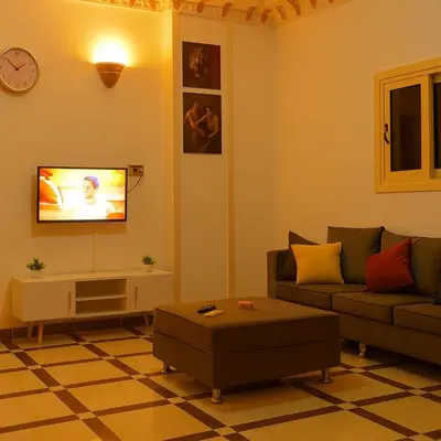 a living room with a couch and a tv at Casa De Amor in Abu Dabab