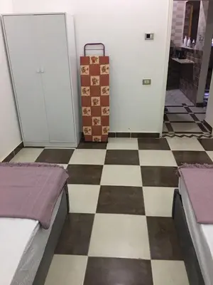 a room with a checkerboard floor with a suitcase at Casa De Amor in Abu Dabab