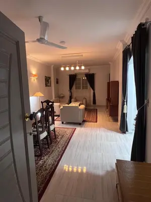 a living room with a couch and a table at Spacious Luxury Nile-View Apartment on Upper Floor with Rooftop, Jacuzzi & BBQ ,Steps from Hilton Hotel in Luxor