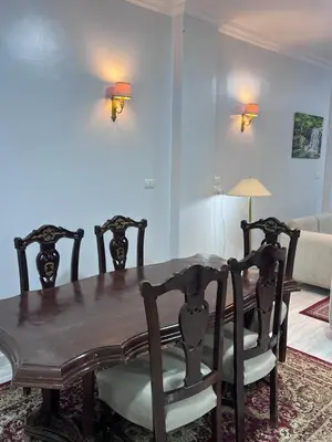 a dining room with a wooden table and chairs at Spacious Luxury Nile-View Apartment on Upper Floor with Rooftop, Jacuzzi & BBQ ,Steps from Hilton Hotel in Luxor