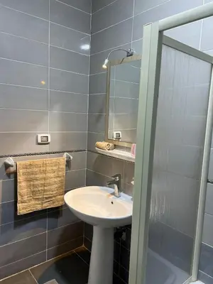 a bathroom with a sink and a mirror at Spacious Luxury Nile-View Apartment on Upper Floor with Rooftop, Jacuzzi & BBQ ,Steps from Hilton Hotel in Luxor
