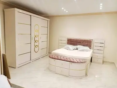 a bedroom with a bed and a large chest of drawers at الأقصر الضبعيه in Al Baghdādī