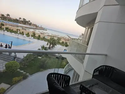 a balcony with two chairs and a view of the beach at Scandic Beach Luxury in Hurghada