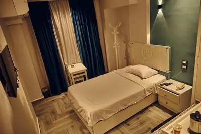 a small bedroom with a bed and a night stand at Town Hotel- Hurghada in Hurghada