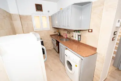 a small kitchen with a washing machine and a washer at White Flower Flats in Luxor