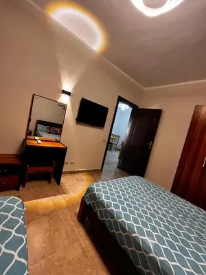 a bedroom with a bed and a desk and a mirror at Florenza Khamsin GH in Hurghada