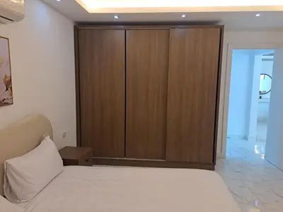 a bedroom with a large wooden cabinet and a bed at Amazing Apartment in Fanadir Hotel with Nice View F408 in Hurghada
