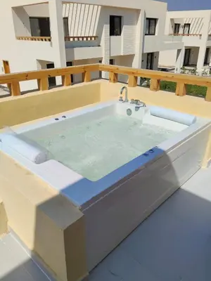 a bath tub with a sink on a balcony at One B2b Apartment w balcony with Jacuzzi at Makadi Heights in Hurghada