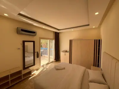 a bedroom with a white bed and a mirror at شاليه في قرية ميراج in Hurghada
