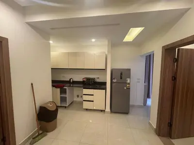 a kitchen with a stainless steel refrigerator and white cabinets at شاليه في قرية ميراج in Hurghada