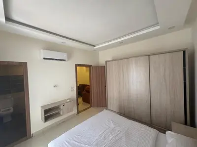 a bedroom with a large bed and a room with a fireplace at شاليه في قرية ميراج in Hurghada