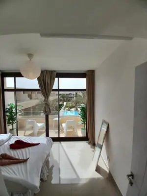 a bedroom with a bed and a view of a pool at Gcribs Onebedroom Elgouna in Hurghada