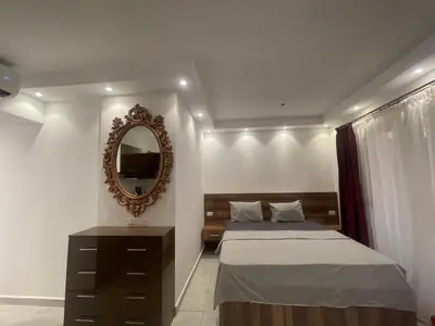 a bedroom with two beds and a mirror at Florenza Khamsim 307 in Hurghada