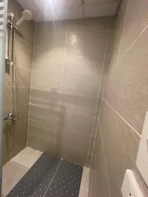 a bathroom with a shower with a tiled wall at Florenza Khamsim 307 in Hurghada