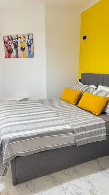 a bed with yellow pillows in a room at Stylish 2BD 2Bath Regency towers in Hurghada