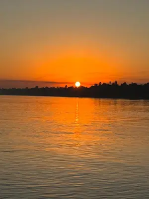 a sunset over a large body of water at Aswan felucca sailing boat in Aswān