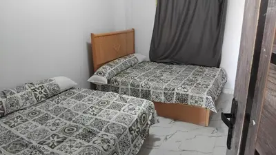 a small room with two beds and a bed and a crib at Oasis Marena in Hurghada