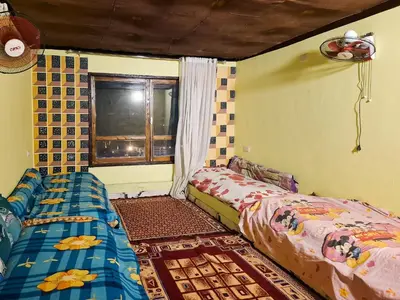 a bedroom with two beds and a window at Nubian Home by Sara in Nag` el-Ramla