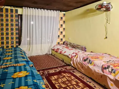 a bedroom with two beds and a window at Nubian Home by Sara in Nag` el-Ramla