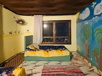 a bedroom with a bed in a room with a window at Nubian Home by Sara in Nag` el-Ramla