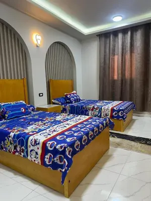 a bedroom with two beds with blue comforters at Elite Apartment Hurghada in Hurghada