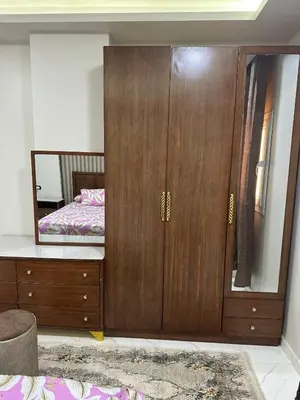 a large wooden cabinet in a bedroom with a bed at Elite Apartment Hurghada in Hurghada