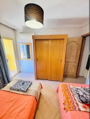 a bedroom with two beds and a closet at Elegant 2BR Retreat in Secure Resort Community in Hurghada