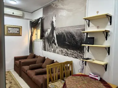 a living room with a couch and a horse picture on the wall at Waleed in Hurghada