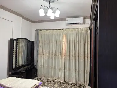 a bedroom with a curtain and a television and a chandelier at Waleed in Hurghada